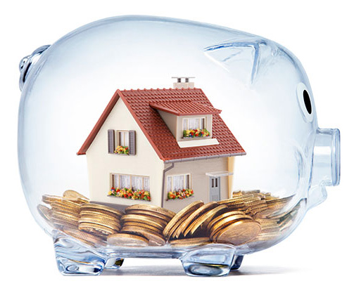 wealth concept showing money and house saved inside a transparent piggy bank
